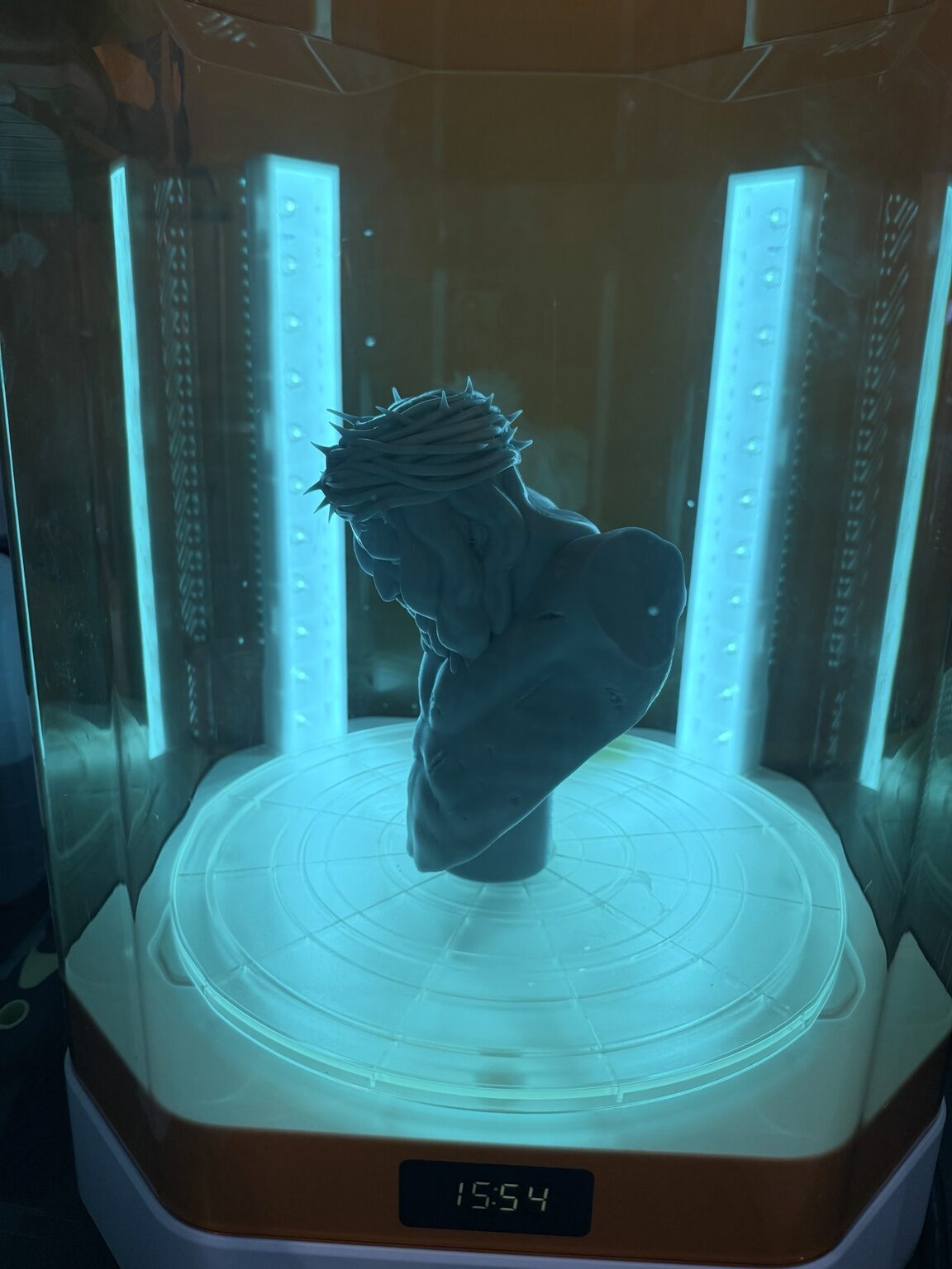 A Christ bust curing under cyan studio lights