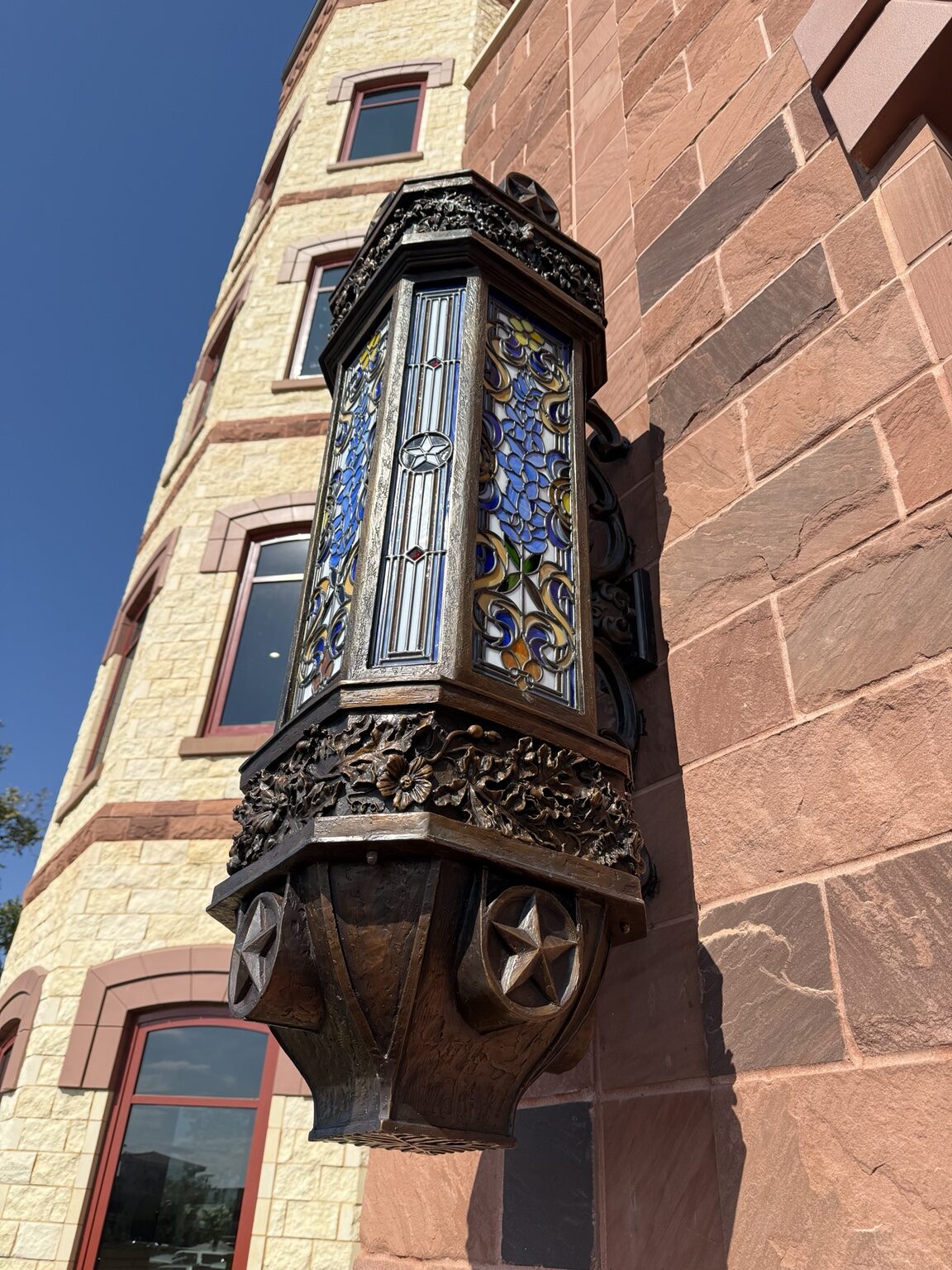 Ornamental architectural lamp with stained glass and sculpted details